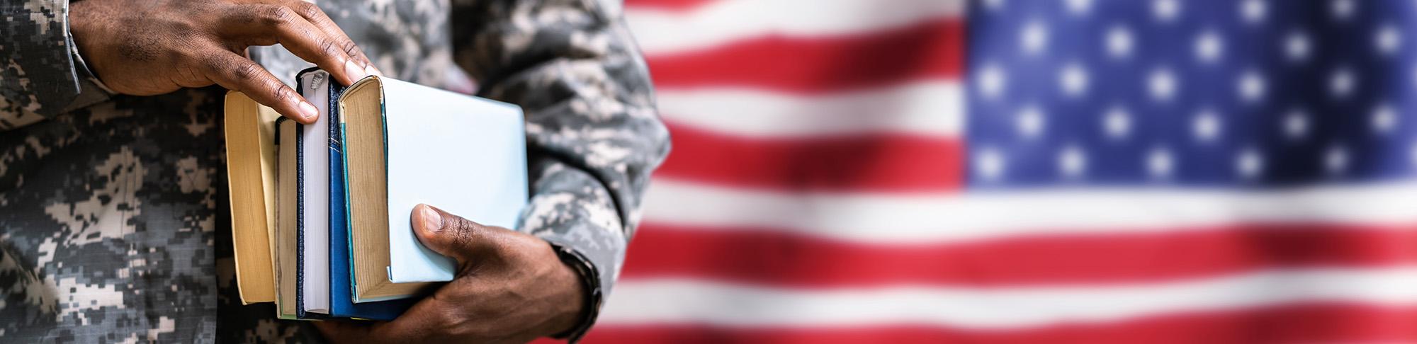 Service member holding book with flag